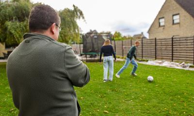 Koen kijkt hoe Ileana en Lias voetballen.