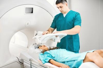 Vrouw ligt op MRI-scanner, radioloog aan haar zijde