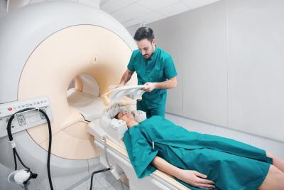 Diagnose NMOSD MRI, jonge vrouw die MRI ondergaat, wordt geholpen door radioloog