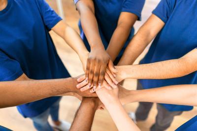 Groep mensen die handen in elkaar slaan