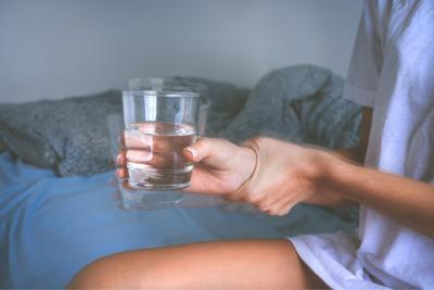 Persoon met tremor met een glas water