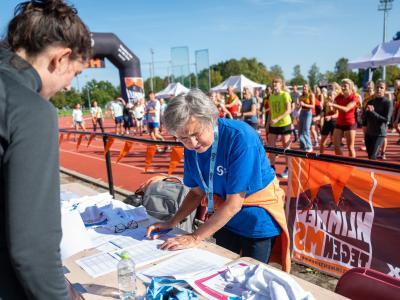 Een deelnemer en vrijwilliger bij inschrijving van Ekiden-actie 2024