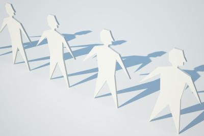 Papieren mannetjes die elkaars hand vasthouden, in een witte neutrale kleur